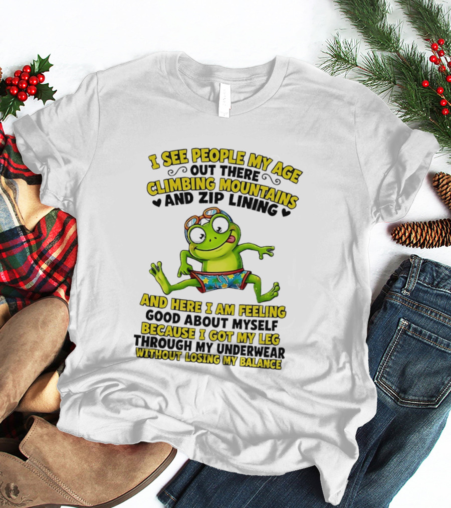 I See People My Age Climbing Mountains And Zip Lining Cartoon Frog Feeling Good Without Losing Balance T-Shirt